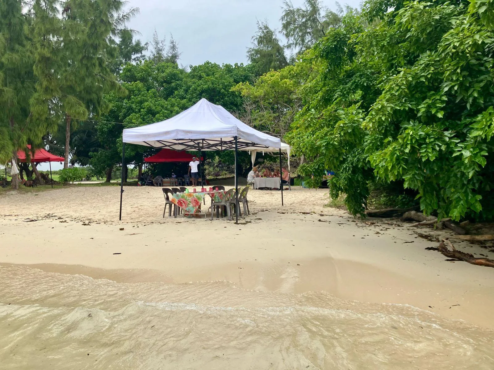 Tables beneath a canopy beside the island beach